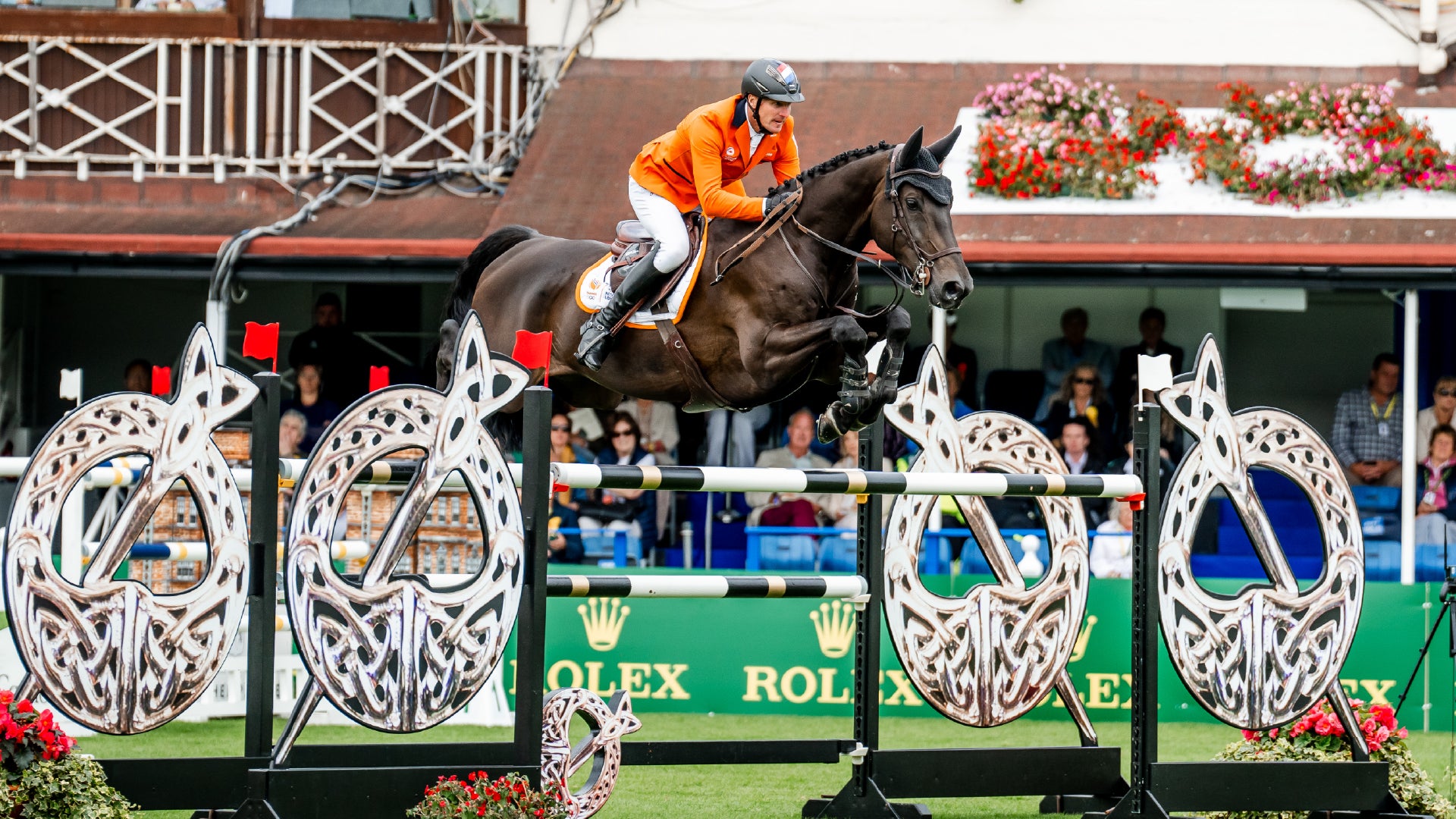 Rider and horse jumping over fence at a show jumping event